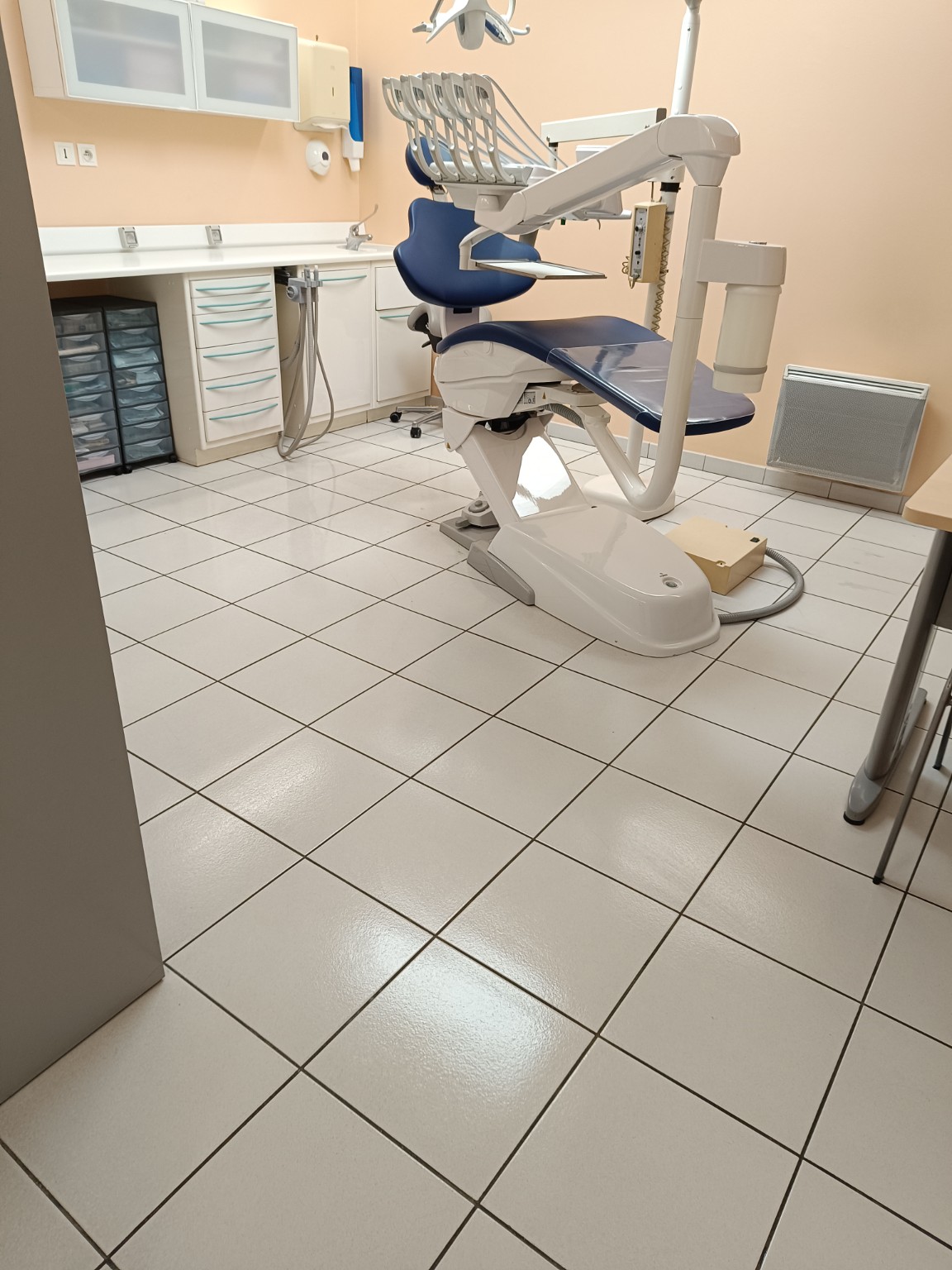 Salle de soins et sol carrelé après nettoyage dans un cabinet dentaire
