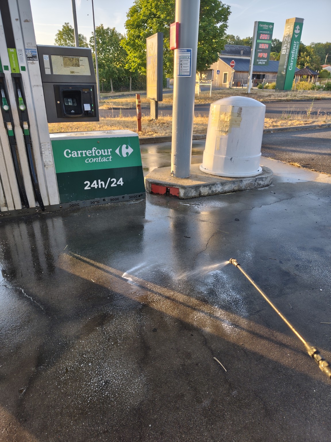 Nettoyage à haute pression du sol d’une station-service en cours d’intervention
